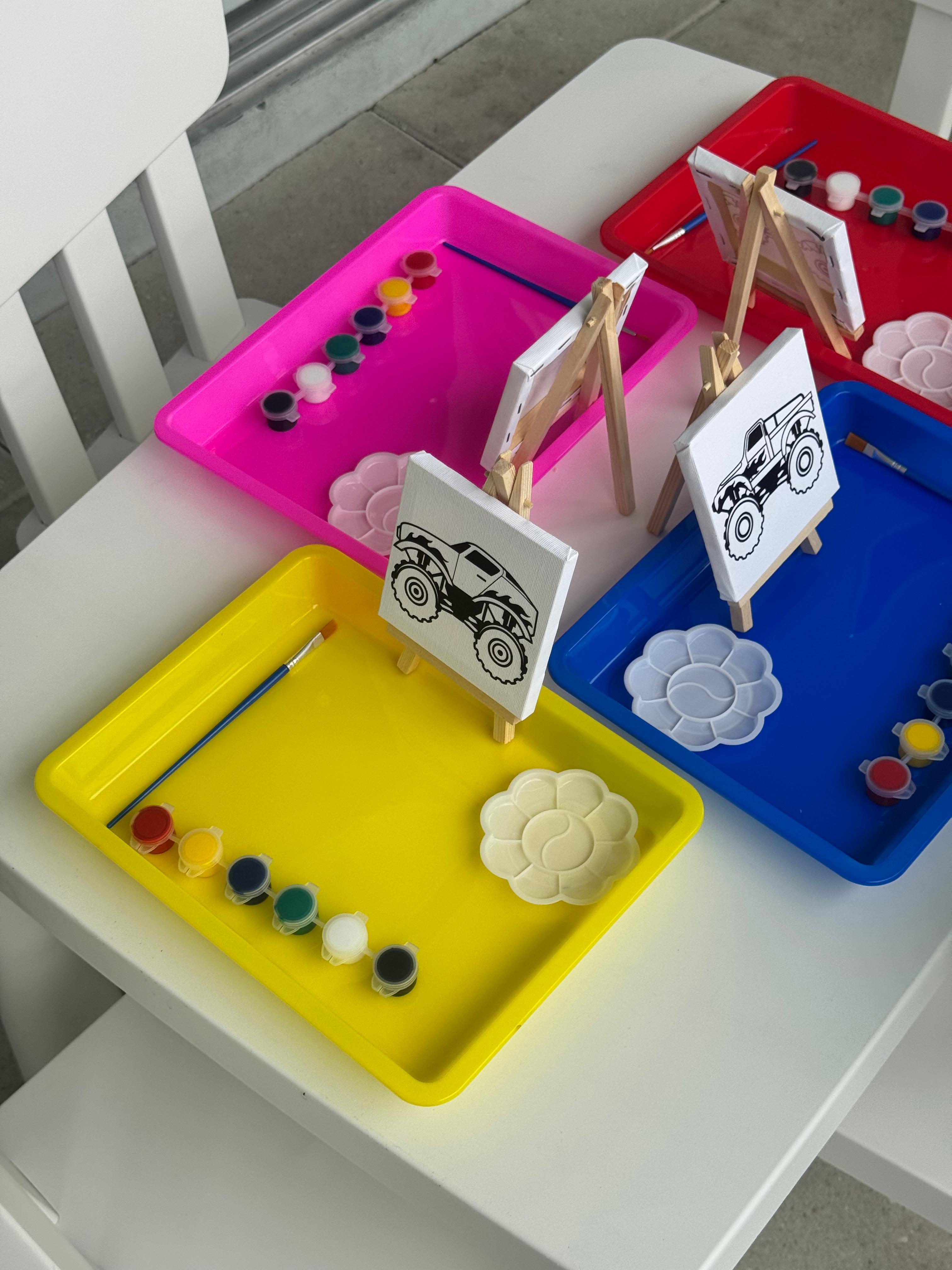 Painting table setup with mini canvases and paints