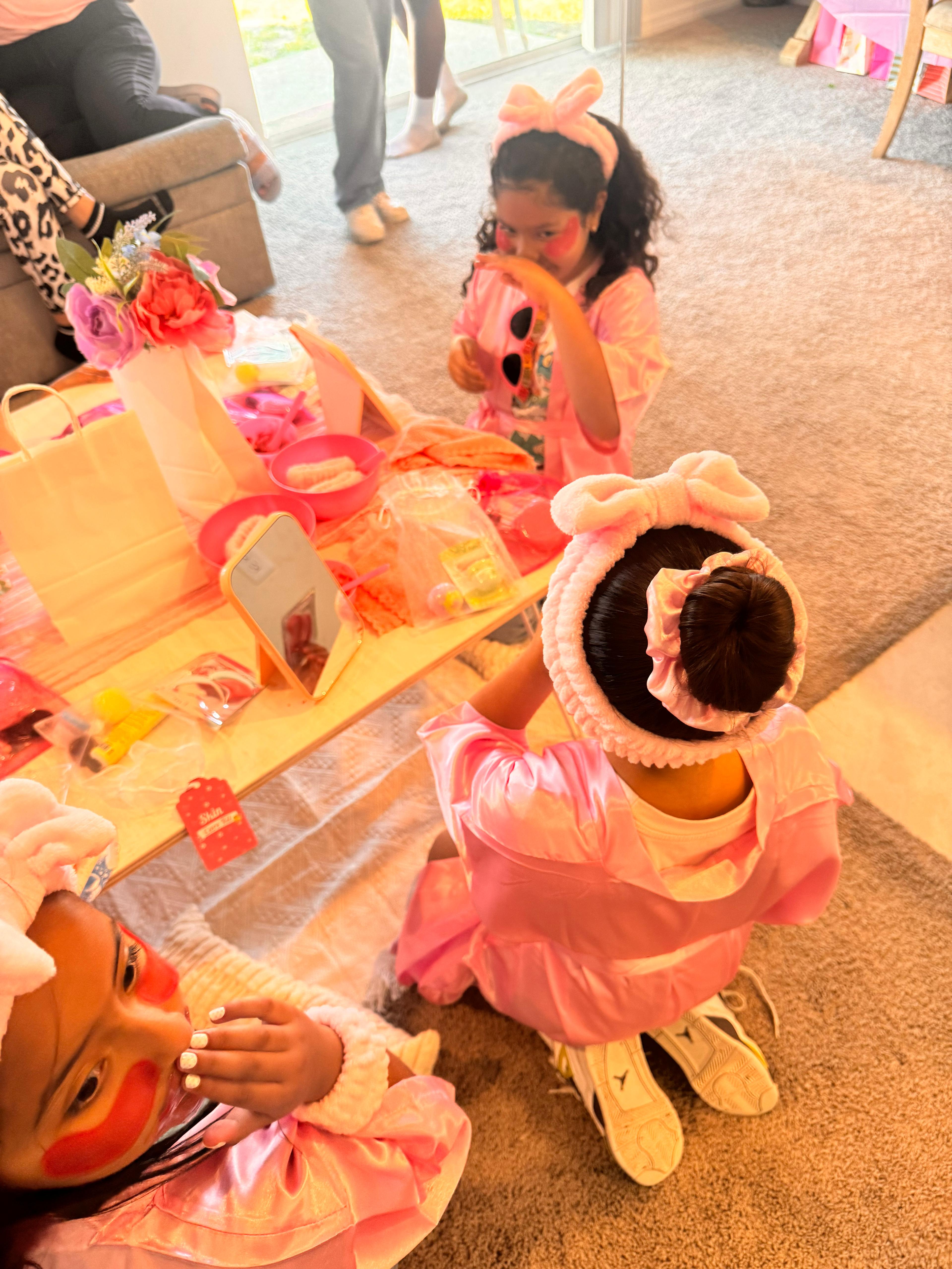 Girls in pink spa robes and headbands doing spa activities at a Sparkle Spa kids party by Titi's Adventure